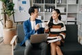 Businesswomen work and discuss their business plans. A Human employee explains and shows her colleague the results paper in modern Royalty Free Stock Photo