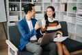 Businesswomen work and discuss their business plans. A Human employee explains and shows her colleague the results paper in modern Royalty Free Stock Photo