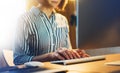 Businesswomen working at office with monitor computer at night, young hipster manager typing on keyboard, female hands texting mes