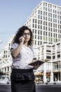 Businnes woman talking on the mobile phone with client and checks the schedule in her notebook Royalty Free Stock Photo