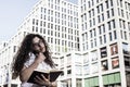 Businnes woman talking on the mobile phone with client and checks the schedule in her notebook Royalty Free Stock Photo