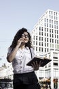 Businnes woman talking on the mobile phone with client and checks the schedule in her notebook Royalty Free Stock Photo