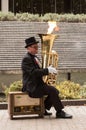 Busker musician playing a tuba with flames coming out from it. Royalty Free Stock Photo