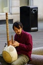 Guy Sat in a City Street Plucking a Kora Stringed Instrument.