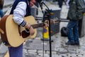 Busker. Singer guitarist with acoustic guitar. Selective focus on foreground