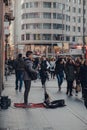 Busker singing and playing guitar on Gran Via street in Madrid, Spain, people walking past