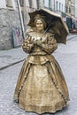 Busking mime in the retro costume with umbrella on street of Lviv, Ukraine
