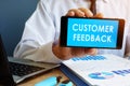 Busnessman holding phone with Customer Feedback. Royalty Free Stock Photo