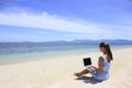 Bussines woman working on the beach with a laptop Royalty Free Stock Photo