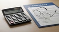 Business Contract, Calculator, and Reading Glasses on Wooden Desk Royalty Free Stock Photo