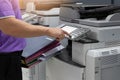 Bussinessman using copier machine to copy heap of paperwork in office Royalty Free Stock Photo