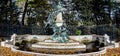 A bust of French artist Eugene Delacroix in in the middle of a scenic fountain with yellow autumn leaves scattered around, Paris