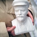 A bust of Vladimir Ilyich Lenin is sold in a store, a woman holds a sculpture of the founder of the USSR