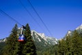 BUSTENI, ROMANIA - AUGUST 2, 2017: Blue cable car cabin transports tourists from Busteni resort up to Bucegi Mountains plateau, Royalty Free Stock Photo