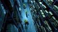 the bustling activity within a warehouse as workers navigate among towering shelves filled with cardboard boxes, seen Royalty Free Stock Photo