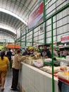 bustling atmosphere inside a traditional market with shoppers at the stalls