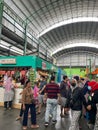 bustling atmosphere in a traditional market with a stall full of groceries and several buyers