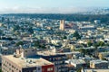 Bustling city with a great many buildings houses and businesses in midday sun with moutains and foggy clouds Royalty Free Stock Photo