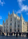 Bustling city square with a crowd of people strolling near the Milan Cathedral
