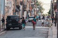 Bustling city street in Matanzas, Cuba with parked vehicles and people