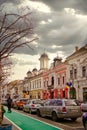 Bustling Cluj-Napoca city street, featuring pedestrians and vehicles in motion