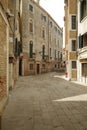 Bustling Italian cityscape with narrow, cobblestone streets lined with buildings in Venice