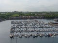 Bustling marina full of sailboats, motorboats, and yachts, all moored in the harbor