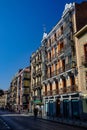 Bustling street in a cityscape featuring a row of tall buildings