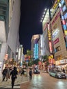 Bustling street scene filled with people. Night time in Shinjuku district. Tokyo, Japan.