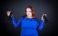 Busty girl in a blue dress holding black shoes and doubts in their choice Royalty Free Stock Photo