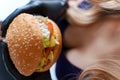 Busty girl holding a hamburger Royalty Free Stock Photo