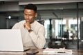 Busy African business man thinking on online investment working on laptop. Royalty Free Stock Photo