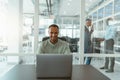 Busy african businessman workingon laptop while sitting in modern coworking