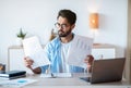 Busy Arab Male Entrepreneur Working With Papers And Laptop In Office Royalty Free Stock Photo