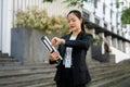 A busy Asian businesswoman is checking time on her wristwatch while walking in the city street Royalty Free Stock Photo