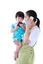 Busy asian mother using smartphone and carrying her daughter. I