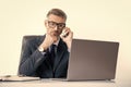 busy businessman in eyewear talking on phone in office with laptop Royalty Free Stock Photo