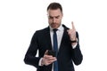 Busy businessman gesturing to wait and typing on phone Royalty Free Stock Photo