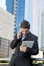 Busy businessman holding digital tablet and mobile phone overworked outdoors Royalty Free Stock Photo