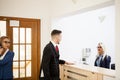Businessman in office reception area talking with secretary Royalty Free Stock Photo