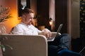 Busy businessman sing laptop while sitting in soft armchair Royalty Free Stock Photo