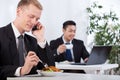 Busy businessmen eating lunch in office Royalty Free Stock Photo