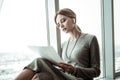 Busy businesswoman sitting on window sill preparing for meeting