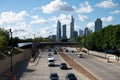 Busy city highway filled with cars and a towering skyline in the background