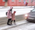 Busy city people on zebra crossing in motion blur. Winter snowy day