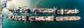 busy coastal harbor from above, with ships docked, cargo being loaded, and the comings and goings of maritime activity