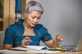 Busy and concentrated attractive middle aged Asian woman working at office laptop computer desk focused and efficient in business Royalty Free Stock Photo