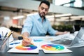 Busy concentrated smart attractive millennial arab guy designer with beard in shirt working on project at table Royalty Free Stock Photo