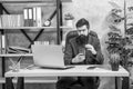 busy confident bearded boss study online on laptop hold coffee in the office, modern life