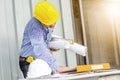 Busy construction engineer talking on phone while carrying blueprints with checking the building progress Royalty Free Stock Photo